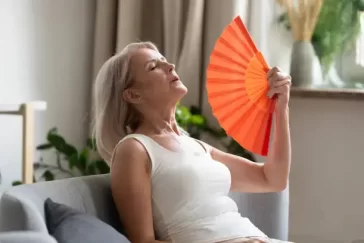 Femme âgée se ventilant avec un éventail.